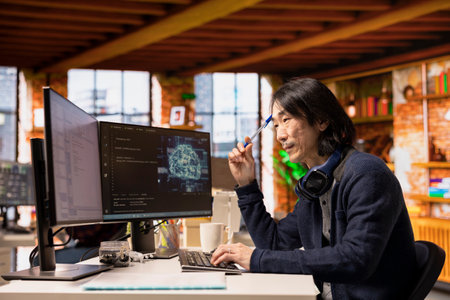Software developer in small business workspace using computer to oversee artificial intelligence...