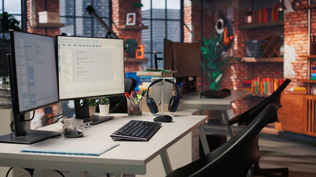 PC in startup office used to design and implement algorithms enabling machine learning. Technology unicorn venture workspace with PC used to conduct code reviews to fix bugs, jib down shotの写真素材