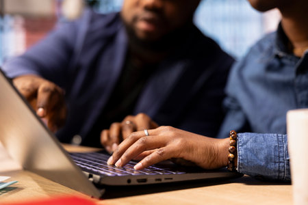 African American man and woman sits at a stylish home office, brainstorming ideas for their digital business, using modern technology to improve communication and project efficiency.の写真素材