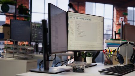 Advanced AI algorithms running on computer monitors in empty startup workspace deploying machine learning models. Coding platform on PC screens in Silicon Valley office, close up shotの写真素材