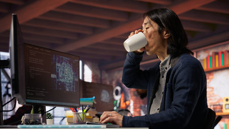 CTO manager in AI startup drinking coffee while coding applications in programming languages. Chief...