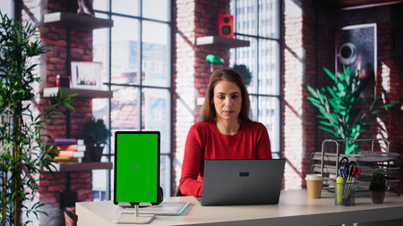 Confident woman solving tasks on a freelance platform next to mockup screen, answering emails and...