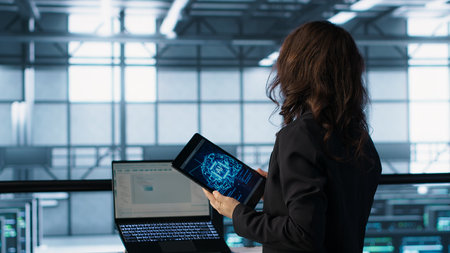 Technician in data center using AI tech on tablet to adjust power management settings. Engineer in...
