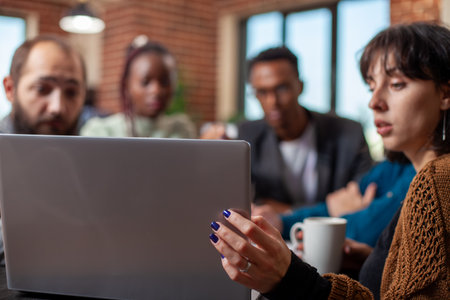 Closeup of a collaborative discussion among diverse colleagues, looking at online documents on...