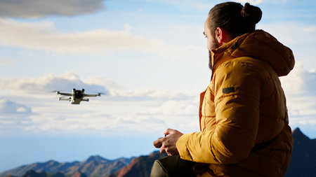 Male influencer shares his hiking journey through a vlog with the drone, recording high quality aerial view content with remote control. Young hiker content creator filming the scenery. Camera B.の写真素材
