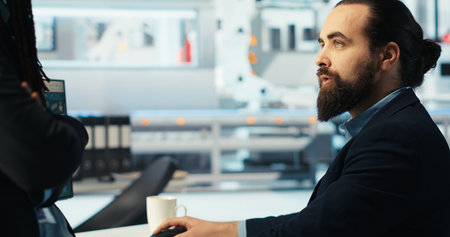 Photovoltaics factory manager brainstorms with colleague, analyzing data, reviewing metrics. Solar...