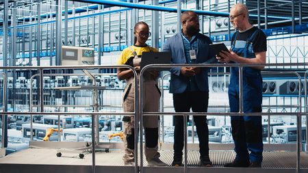 Industry 4.0 photovoltaics plant manager overseeing work done by employees to maximize solar cells power generation. Solar panels smart factory supervisor coordinating technicians.の写真素材