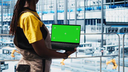 Smart factory technician manages robotic arms using mockup notebook, close up. Engineer in industry...