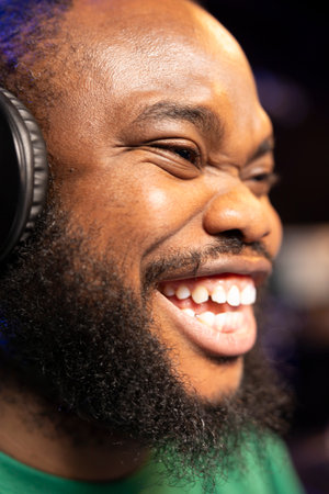 Smiling audio engineer feeling confident with his new music, editing his tunes and adding sound...