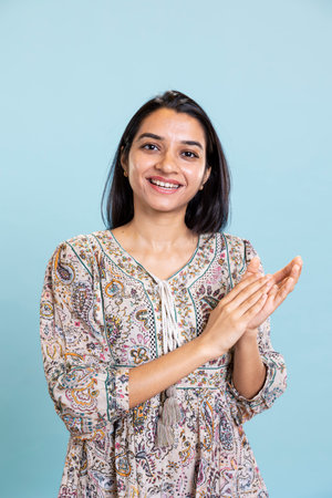 Indian satisfied woman clapping hands and feeling proud of a milestone in studio, pleased and...