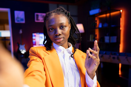 POV of social media star using smartphone camera to capture welcoming intro for vlogging channel. Influencer connecting with loyal audience during livestream, filming with selfie stickの写真素材