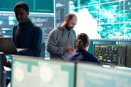 Governmental hackers working on computer network in high tech office, focusing on data security and...