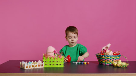 Small sweet child decorating eggs with stamps and watercolor, preparation for easter sunday holiday....