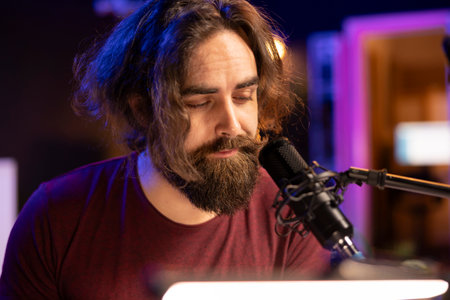Talented musician producer singing a new song on microphone in home studio, composing music an...