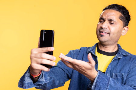 Excited upbeat adult talking to a friend over web conference call on smartphone, waving hand at the webcam. Ecstatic happy person communicating with people, online connection.の写真素材