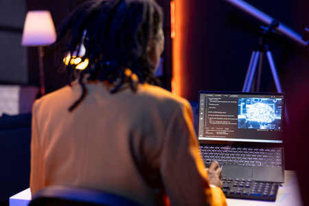 Data scientist using laptop in home office, updating artificial intelligence machine learning...