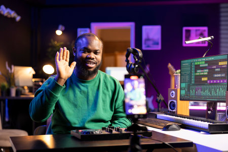 Skilled audio engineer teaching online mixing tunes lessons by using a smartphone on tripod to...