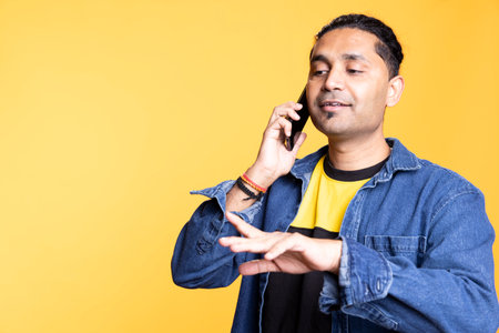 Happy person in casual outfit chatting with best friend over telephone call, discussing with people and keeping in touch. Joyous guy in casual attire communicating with mate using phone.の写真素材