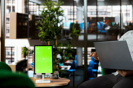 Green screen tablet and laptop used by staff member preparing for business meeting. Mockup device...
