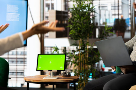 Green screen tablet next to employees implementing strategy to guide organization towards growth. Mockup device next to worker working to achieve performance targets for operational efficiencyの写真素材