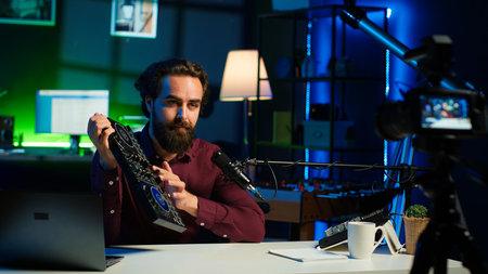 Man filming technology review, recommending newly launched DJ controller. Influencer advocating for high quality sound mixer device in front of followers after testing it, camera Aの写真素材