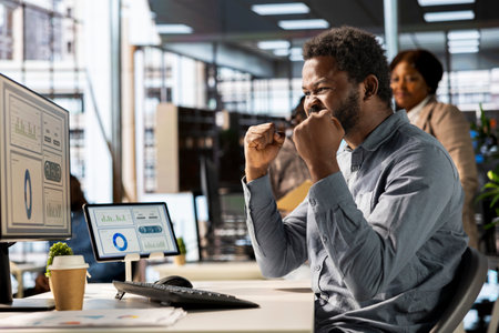 Happy corporate employee celebrating a major project milestone, thrilled with the successful outcome. Enthusiastic analyst smiles at desk, proud and satisfied of career growth professional victory.の写真素材