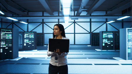 Programmer walking in data center, using notebook to design, implement and manage gear, ensuring...