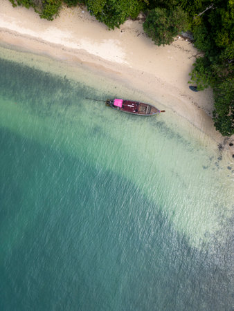 Aerial view of a tropical island with sailboats in a bay, stunning travel destination featuring sailboats drifting in a calm lagoon. Palm trees, golden beaches and a turquoise ocean.の写真素材