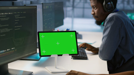 Data center programmer using mockup tablet, maintaining company network infrastructure, close up. Server hub worker ensuring optimal system performance with isolated screen device, camera Aの写真素材