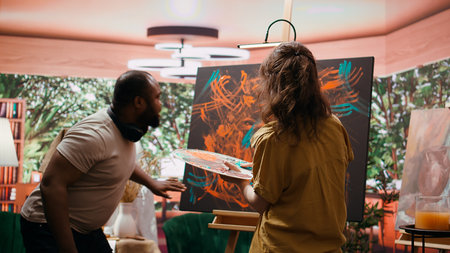 In a creative workshop, female artist mixes pigments with fingers to achieve the perfect hue. The creation is an abstract masterpiece reflecting finger painting skill and inspiration.の写真素材