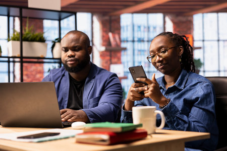 African American man and woman in a stylish loft working remotely, combining creativity and planning...