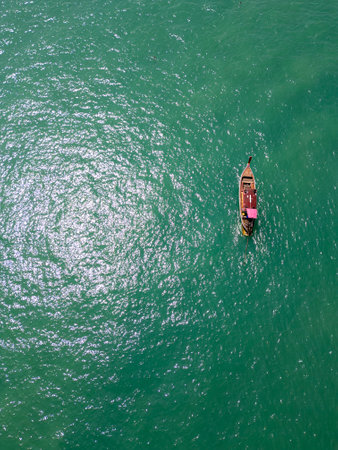 Aerial view of a sailboat cruising along Thailand coastline, breathtaking scene of a motorboat navigating the turquoise waters. Passing by scenic coastal cliffs and a tropical shoreline.の写真素材