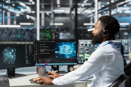 Employee talking in headset mic with technicians setting up data center equipment needed to run...
