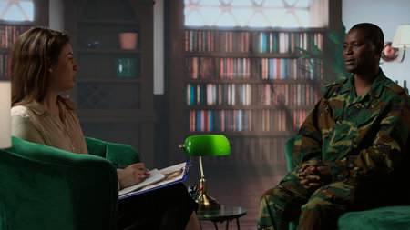 African american serviceman in camouflage uniform sits in therapy, looking depressed and opening up...