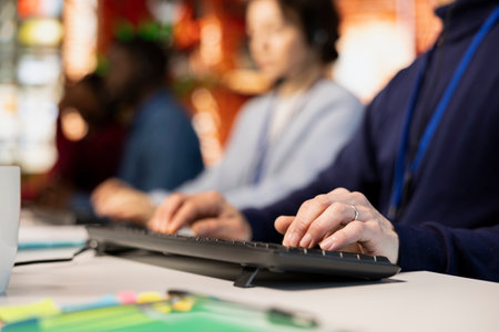 Call center agent typing on PC keyboard, assisting customers through digital communication channels....