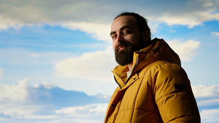 Male explorer embraces the solitude of high altitude wilderness, climbing on top of the mountain for...