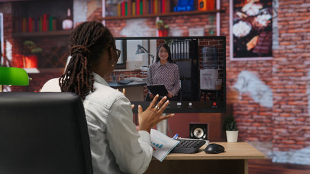 Remote employee calls manager remotely using internet videocall to ask for feedback on project progress. Teleworker at home requesting assistance from team leader in teleconference meeting, camera Bの写真素材