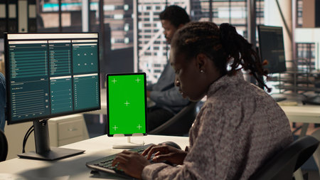Business manager at desk looking at mockup screen and solving tasks for company objectives...