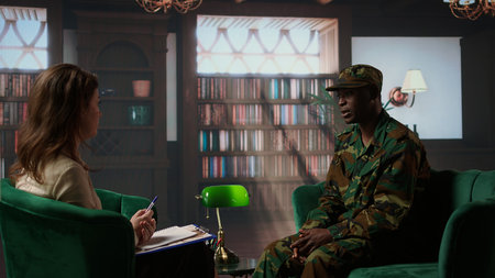 Anxious depressed private sharing his struggles with combat flashbacks, counseling session with psychiatrist for rehabilitation. Psychological support and reintegration for soldiers. Camera A.の写真素材