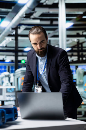 Facility supervisor in a suit monitoring solar panel production line, reflecting professional occupation and executive level involvement in renewable energy development. Solar power.の写真素材