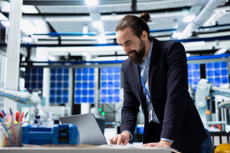 Industrial consultant examines high tech solar energy production line, reviewing insights for clean...