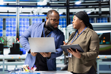 African American engineers industrial coworkers doing teamwork on production line for solar panels,...