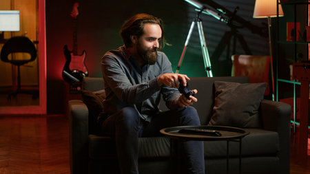 Cheerful gamer rushing home to play newly released game. Happy man jumping on couch, eager to play...