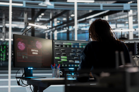 Data center engineer finding critical error in equipment used for machine learning training. Server farm IT expert fixing bugs in computer code affecting artificial intelligence systems performanceの写真素材