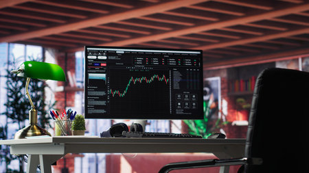 Modern trading setup with monitor running forex trends going up, high end classy apartment workstation. Clean desk provide a professional space for stock exchange analysis. Camera A.の写真素材