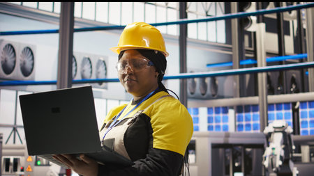 Woman working in industry 4.0 plant using notebook, following maintenance procedures. Smart factory...