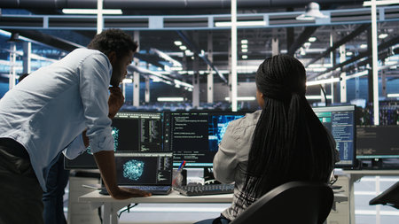 Data center manager supervising worker deploying AI solutions optimizing equipment. Server farm...