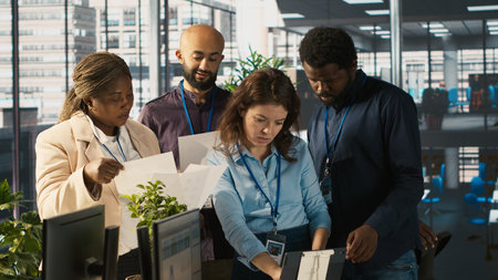 Portrait of smiling workers in office working together on finishing project before deadline, doing...