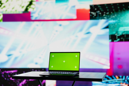 Empty space with a laptop showing green screen mockup next to artistic lights, creating a soundscape for nightlife ambiance and music culture. Spreading the visual art vibes and creativity.の写真素材