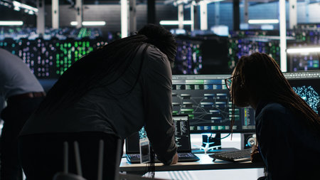 Data center teamworking colleagues use node tree program to identify equipment performance issues. Server hub engineering team coworkers review data analysis graph to minimize failures, camera Bの写真素材
